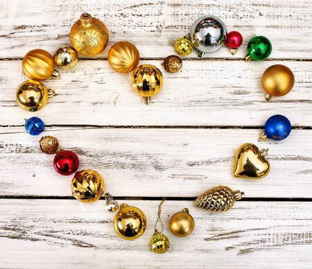 Christmas decorations scattered heart form design top view of Xmas balls ornaments on white wooden table. Square frame.の写真素材