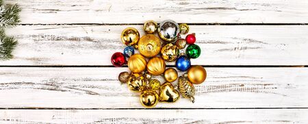 Christmas stack of Xmas balls decorations on white wooden table on horizontal long frame banner with copy space around.の写真素材