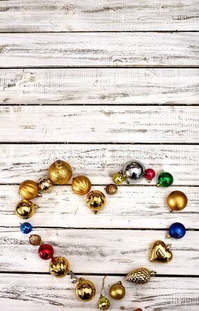 Christmas decorations scattered heart form design top view of Xmas balls ornaments on white wooden table. Vertical long frame with copy space up frame.の写真素材