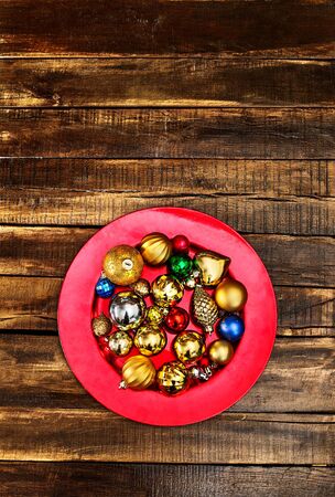 Christmas decorations design top view of Xmas balls ornaments on red plate on wooden boards. Vertical long frame with copy space top.の写真素材