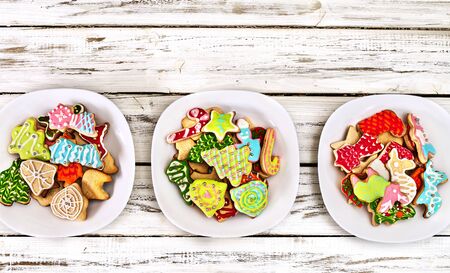 Christmas gingerbread cookies on three plates by white wooden table close up. Top view long horizontal banner design frame with copy space top.の写真素材