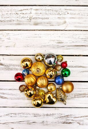 Christmas stack of Xmas balls decorations on white wooden boards on vertical long frame with copy space up frame.の写真素材
