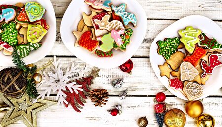 Christmas gingerbread cookies on three plates group by white wooden table . Top view long horizontal banner design frame with copy space top.の写真素材