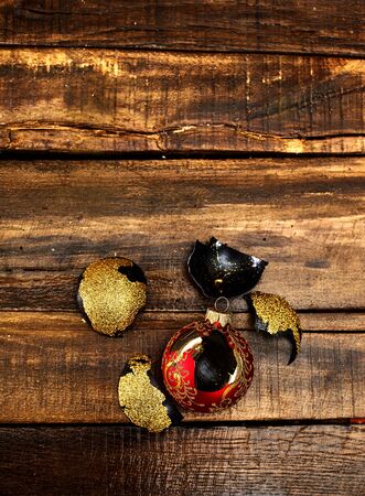 Broken Christmas ball with glass shards on wooden table. Top view of vertical frame.の写真素材