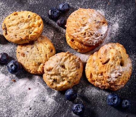 Bakers gonna bake. Serving food on slate. Oatmeal cookies biscuit with blueberry on dark tiles countrylike. Chocolate chip cookies shop on window display. Beautiful table setting.の写真素材