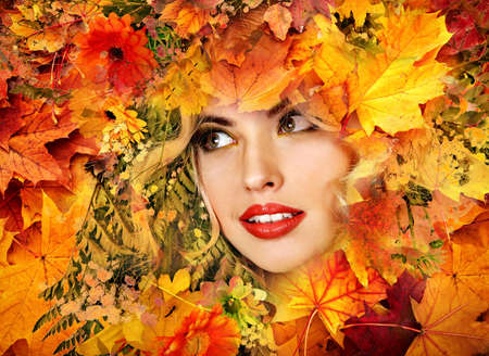 Autumn leaves background with beauty face of beautiful woman close. Fashion dream in red fall color outside.の写真素材