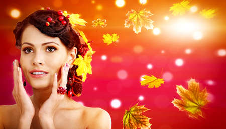 Autumn banners leaves background with beauty face and hands of beautiful woman. Fashion dream in red fall color outside.の写真素材