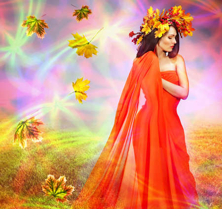 Autumn leaves background with woman. Conceptual fall fashion dream in red fall color of september sun.の写真素材