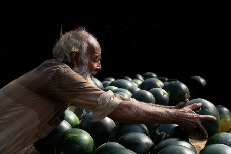 Watermelon sellers old man at a market in india .の写真素材