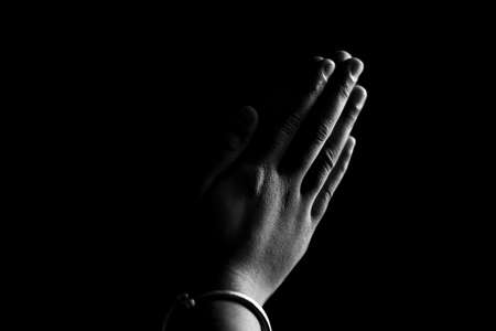Praying hands with faith in religion and belief in God on dark background. Power of hope or love and devotion. Namaste or Namaskar hands gesture. Prayer positionの写真素材