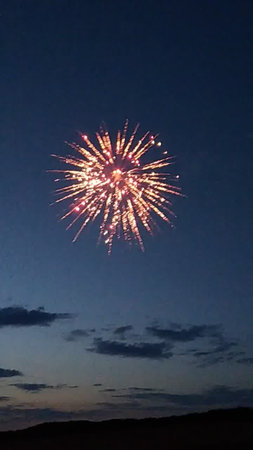 fireworks in the night sky with white clouds and blue sky backgroundの写真素材