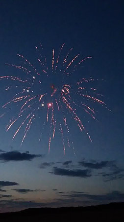 fireworks in the night sky with white clouds and blue sky.の写真素材