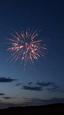 fireworks in the night sky with stars and clouds on the backgroundの写真素材