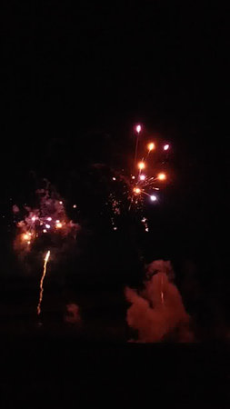 Fireworks in the night sky with smoke and firecrackers.の写真素材