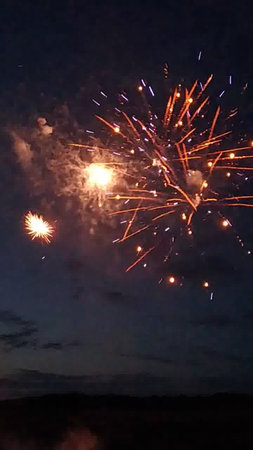 Fireworks in the night sky with clouds and stars in the backgroundの写真素材