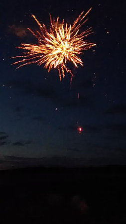 Fireworks in the night sky with clouds and stars in the backgroundの写真素材