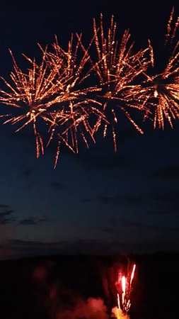Fireworks in the night sky with a lot of red and yellow fireworksの写真素材
