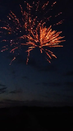 Fireworks in the night sky with clouds and stars in the backgroundの写真素材