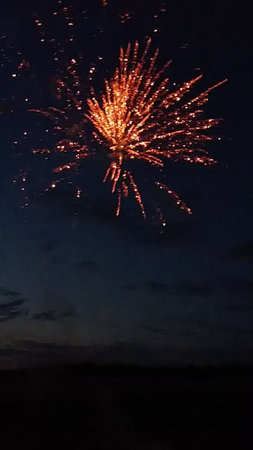 Colorful fireworks of various colors over night sky with silhouette of peopleの写真素材