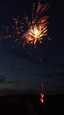 Fireworks in the night sky with clouds and stars in the backgroundの写真素材