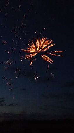 fireworks in the night sky with stars and clouds in the backgroundの写真素材