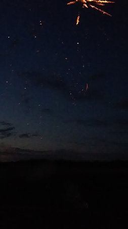 Fireworks in the night sky with clouds and stars in the backgroundの写真素材