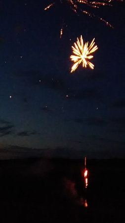 fireworks in the night sky over the sea and the island of Sardiniaの写真素材
