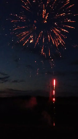 Fireworks in the night sky and the silhouette of the person.の写真素材
