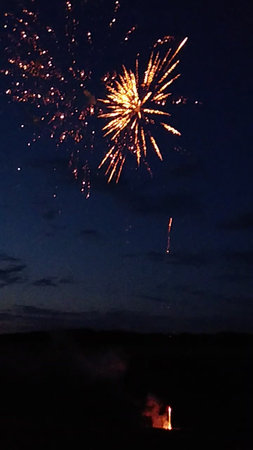 Fireworks in the night sky with clouds and a red firecrackerの写真素材