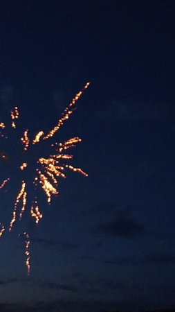 Fireworks in the night sky with a dark background and stars.の写真素材