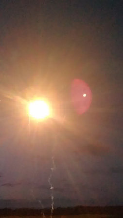 Sunset in the desert. The sun goes down over the horizon.の写真素材