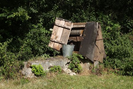 Old countryside water well with a bucket.の写真素材