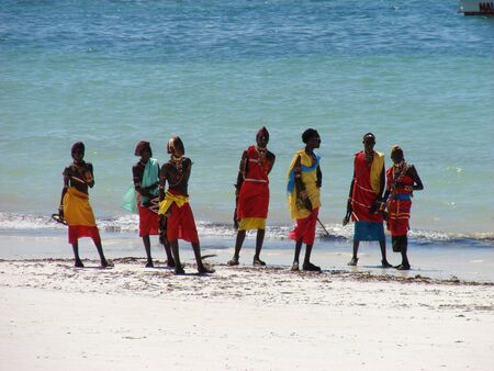 Diani Resort (30 km south of Mombasa), Kenya, Africa 02 May 2007 : Group of male Masai on a beautiful kenyan beach in traditional clothes. Amaizing colors - light sand blue sky and turquoise ocean. のeditorial素材