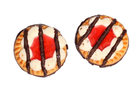Sweet and crunchy biscuits cookies with jelly and striped chocolate on top isolated on whiteの写真素材