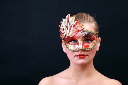 Face of young woman with carnival mask isolated on blackの写真素材