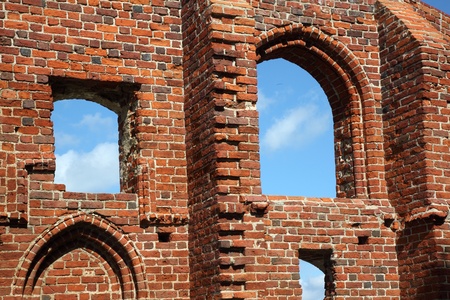 Blue sky in holes on old red brick wallの写真素材