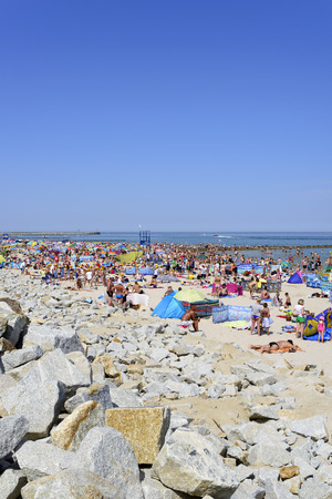 Ustka, Poland - July 04, 2015: The scene on the beach in Ustka during the tourist season on a sunny day. A large group of people of all ages - are visible on the beach. The beach is located on the Baltic Sea.のeditorial素材