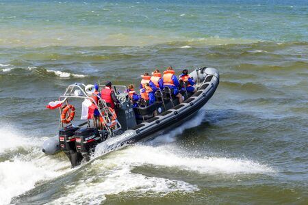 Tourists enjoy a high speed boat ride on the Baltic sea near the harbor on 7 July 2015 in Ustka, Poland.のeditorial素材