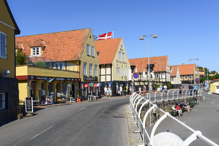 Tourists enjoy the sunny weather and walking through the old town on 14 August 2015 in Svaneke on...