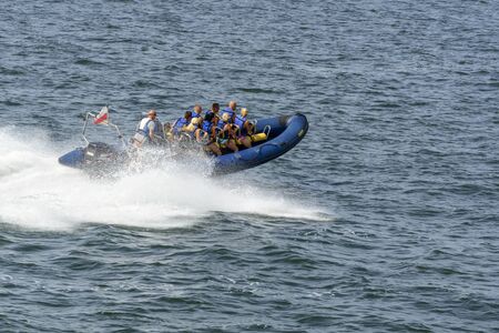 Tourists enjoy a high speed boat ride on the Baltic sea near the harbor on 16 August 2015 in Miedzyzdroje, Poland.のeditorial素材