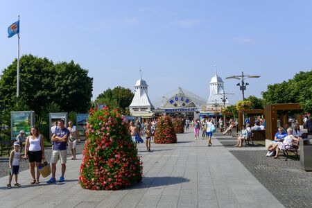 Tourists enjoy the sunny weather and walking in front of the entrance to the pier on 16 August 2015 in Miedzyzdroje, Poland.のeditorial素材