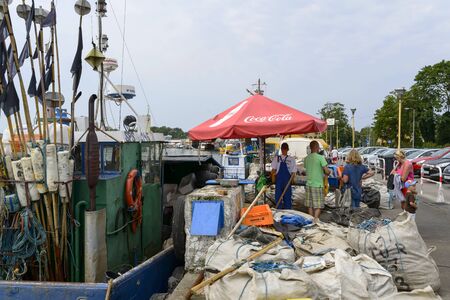 People buy fresh fish Directly from the fishing boat on 16 August 2015 in Dziwnow, Poland.のeditorial素材
