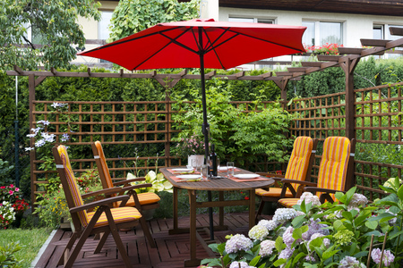 Wooden furniture with umbrella in backyard patio.の写真素材