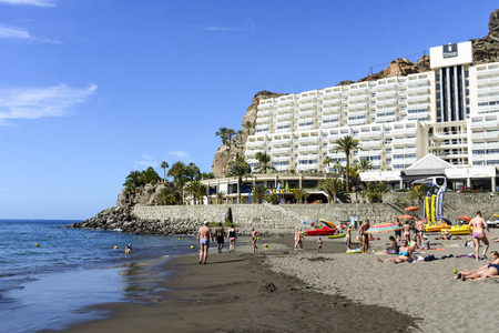 Tourists enjoy the sunny weather and relaxing on the Atlantic ocean beach on 26 November 2015 in Taurito, Gran Canaria Island.のeditorial素材