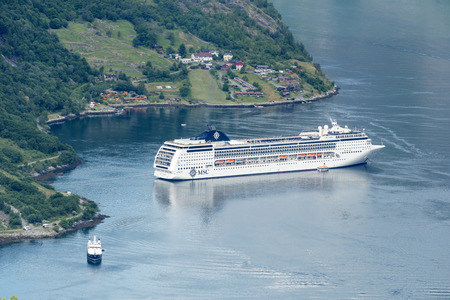 Cruise liner in the Geirangerfjord sea port with tourists on June 29, 2016 in Geiranger, Norway. Geirangerfjord is famous place and UNESCO heritage site.のeditorial素材