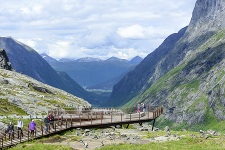 Tourists on a viewing platform near the Trollstigen road between the mountains on June 29, 2016 in Geiranger, Norway. Geirangerfjord is UNESCO heritage site.のeditorial素材