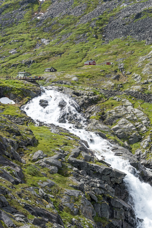 Tourists on a viewing platform near the Trollstigen road between the mountains on June 29, 2016 in Geiranger, Norway.のeditorial素材