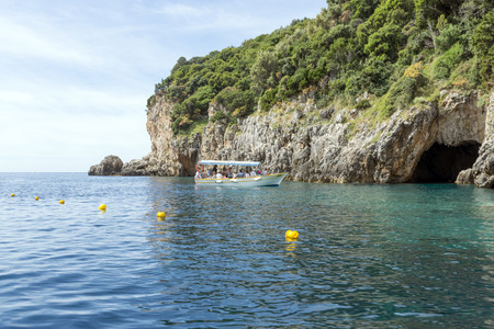 Tourists on the boat visit the caves on the Ionian Sea coast on May 15, 2017 in Paleokastritsa resort, Corfu island in Greece.のeditorial素材
