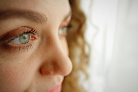 eyes close up of a beautiful curly girl on a light background