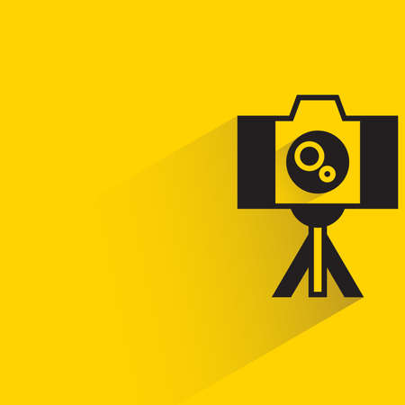 digital camera on tripod with shadow on yellow backgroundのイラスト素材